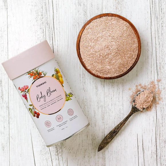 Tropeaka Body Bloom powder in wooden bowl with spoon